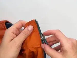 Slide the damaged zipper slider up and off the zipper tape.